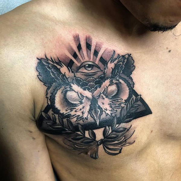 A person's chest with a all seing eye pyramid tattoo