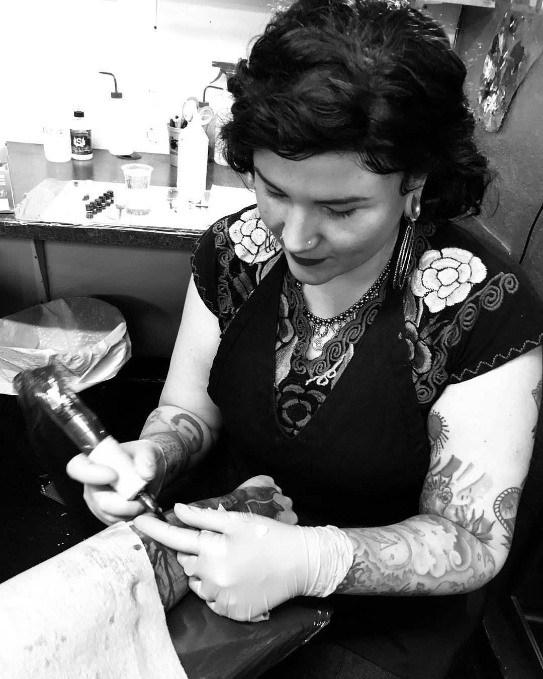 Lola tattooing a client 