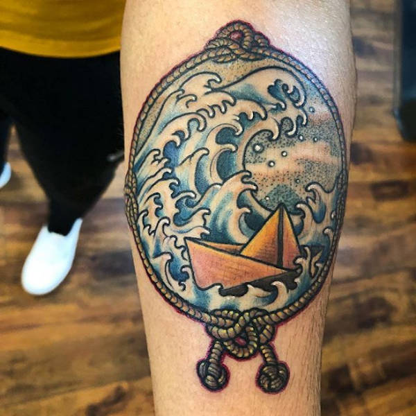A boat on a storm tattoo on the arm.